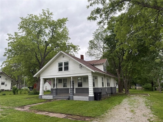 347 Walnut St, Kidder, MO 64649 - view of front facade with covered porch, a chimney, a front lawn, and driveway