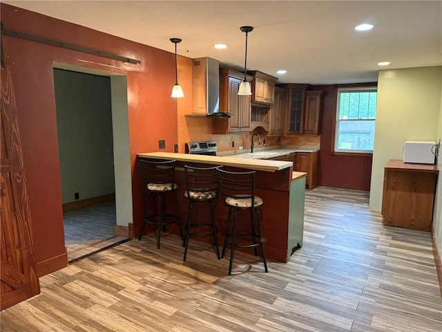 347 Walnut St, Kidder, MO 64649 - kitchen with a sink, a peninsula, light wood-style flooring, glass insert cabinets, and recessed lighting