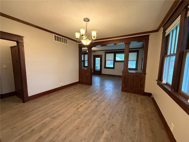 347 Walnut St, Kidder, MO 64649 - unfurnished dining area featuring ornamental molding, a chandelier, baseboards, ornate columns, and light wood finished floors