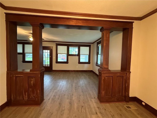 347 Walnut St, Kidder, MO 64649 - unfurnished living room featuring ornate columns, light wood-style flooring, and ornamental molding