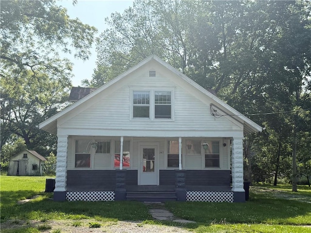 347 Walnut St, Kidder, MO 64649 - bungalow with a front lawn, covered porch, and an outbuilding