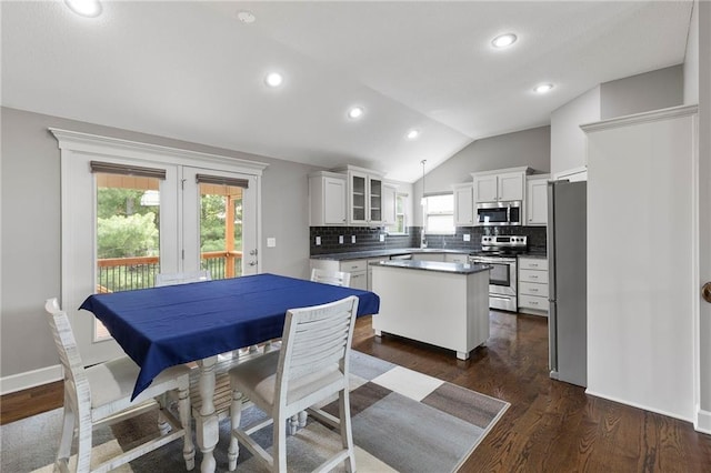 21419 W 47th Ter, Shawnee, KS 66218 - kitchen featuring stainless steel appliances, vaulted ceiling, a center island, tasteful backsplash, and dark countertops
