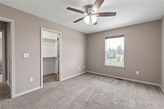 21419 W 47th Ter, Shawnee, KS 66218 - unfurnished bedroom featuring carpet flooring, a walk in closet, baseboards, ceiling fan, and a textured ceiling