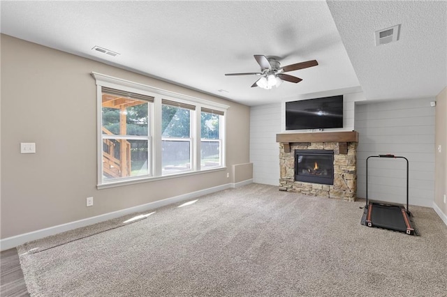 21419 W 47th Ter, Shawnee, KS 66218 - unfurnished living room featuring a textured ceiling, a fireplace, a ceiling fan, baseboards, and carpet floors