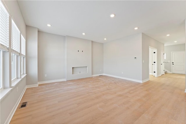 18257 W 166th St, Olathe, KS 66062 - unfurnished living room with light wood-style flooring, a fireplace, and recessed lighting
