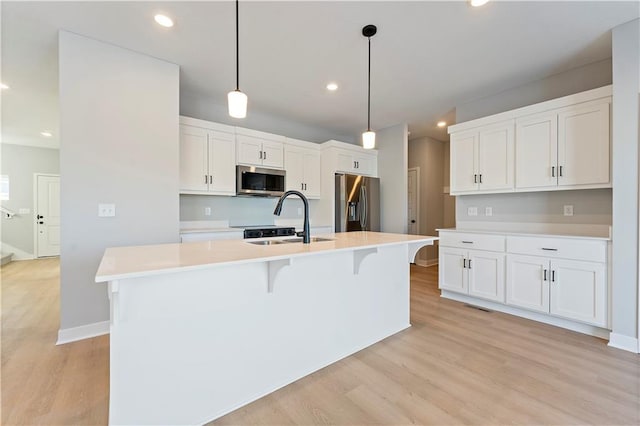 18257 W 166th St, Olathe, KS 66062 - kitchen featuring appliances with stainless steel finishes, light wood-style floors, white cabinetry, recessed lighting, and light countertops