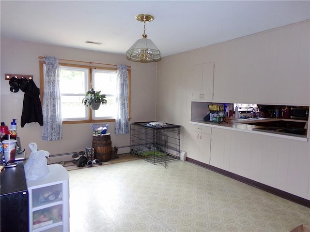 4426 Shrine Park Rd, Leavenworth, KS 66048 - kitchen with white cabinets, light countertops, a sink, decorative light fixtures, and light floors