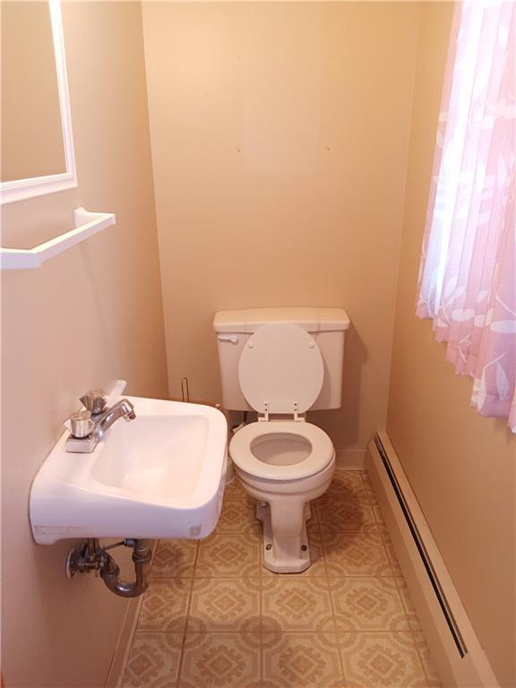 4426 Shrine Park Rd, Leavenworth, KS 66048 - bathroom featuring a baseboard heating unit, a sink, toilet, tile patterned floors, and baseboards