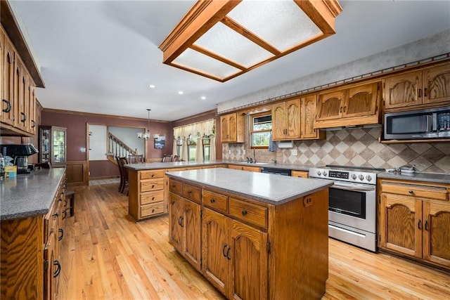 19819 Mclouth Rd, Tonganoxie, KS 66086 - kitchen featuring black appliances, a peninsula, brown cabinets, light wood-style floors, and a center island