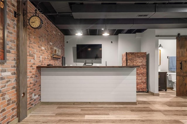 10154 N Lane Dr, Kansas City, MO 64157 - indoor wet bar with wood finished floors, a barn door, and brick wall