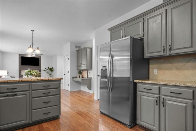 10154 N Lane Dr, Kansas City, MO 64157 - kitchen featuring stainless steel fridge, gray cabinetry, decorative backsplash, and light wood-type flooring