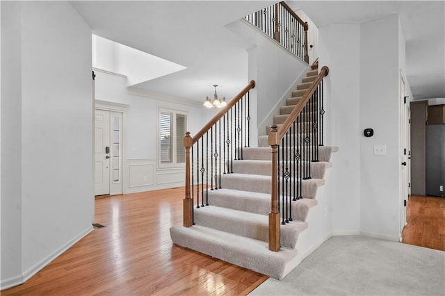 10154 N Lane Dr, Kansas City, MO 64157 - stairs featuring a chandelier, wood finished floors, and baseboards