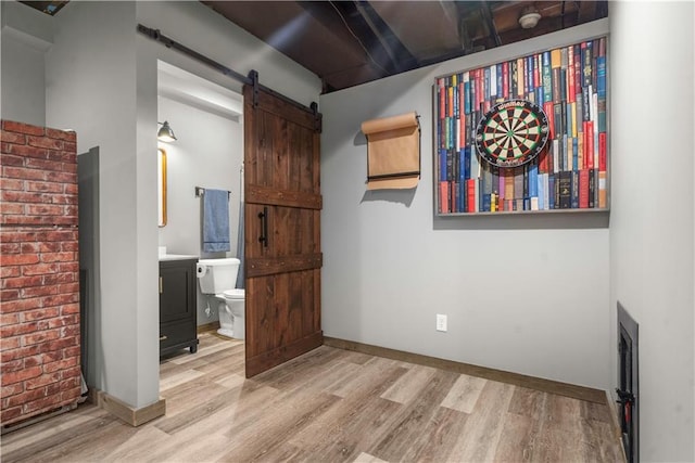 10154 N Lane Dr, Kansas City, MO 64157 - unfurnished bedroom featuring wood finished floors, a barn door, ensuite bath, and baseboards
