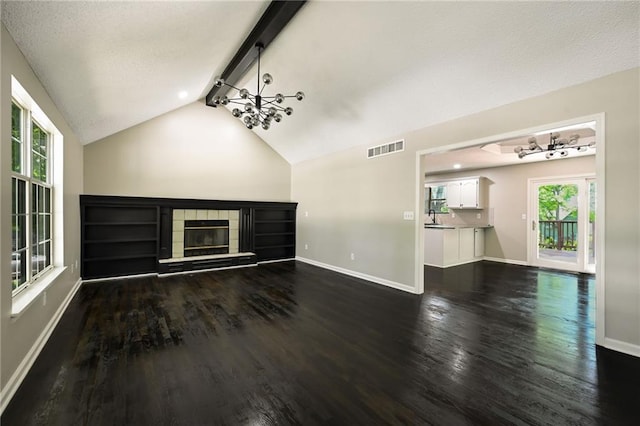 1609 NE Jade Ct, Lees Summit, MO 64086 - unfurnished living room with dark wood-style floors, a tiled fireplace, baseboards, and a textured ceiling