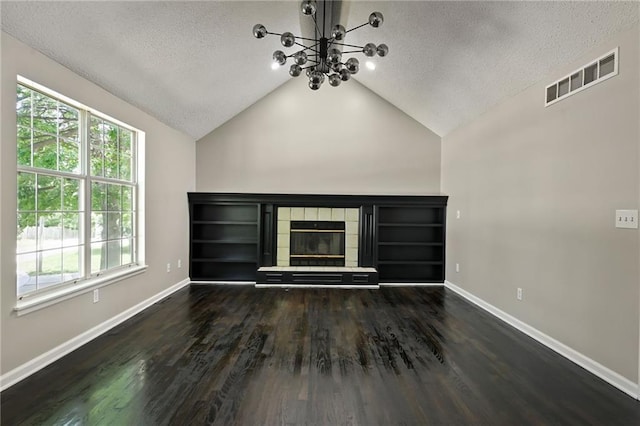 1609 NE Jade Ct, Lees Summit, MO 64086 - unfurnished living room featuring a chandelier, a textured ceiling, wood finished floors, baseboards, and vaulted ceiling