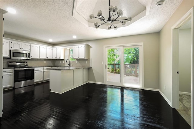 1609 NE Jade Ct, Lees Summit, MO 64086 - kitchen featuring stainless steel appliances, a textured ceiling, a peninsula, white cabinetry, and a sink