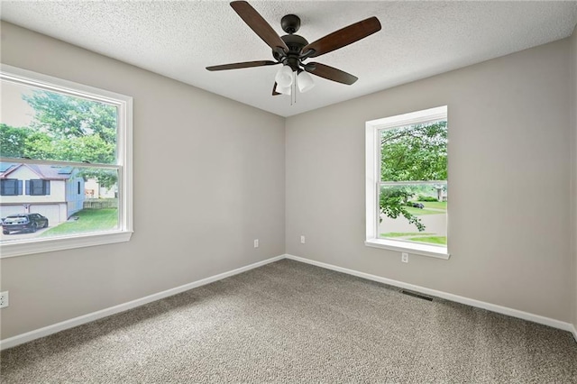 1609 NE Jade Ct, Lees Summit, MO 64086 - carpeted spare room with healthy amount of natural light, a ceiling fan, baseboards, and a textured ceiling