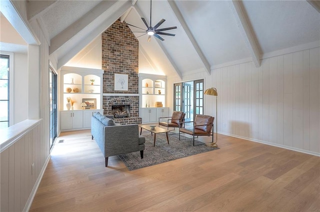9100 Dearborn St, Overland Park, KS 66207 - living area featuring light wood-style flooring, a brick fireplace, built in shelves, a ceiling fan, and wood walls