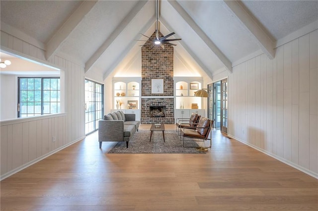 9100 Dearborn St, Overland Park, KS 66207 - living area featuring a ceiling fan, wood finished floors, a fireplace, built in features, and plenty of natural light