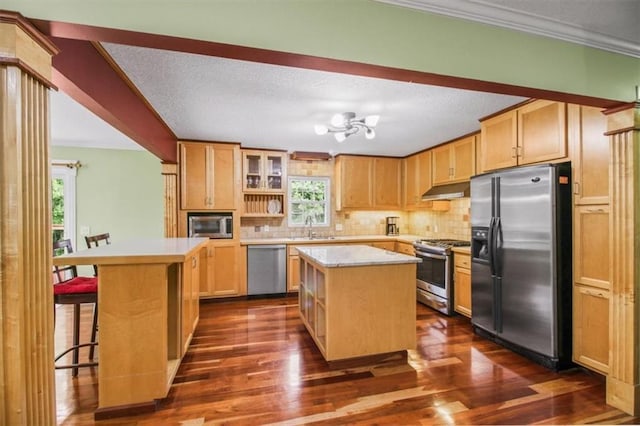 4188 Country Squire Ln, Oak Grove, MO 64075 - kitchen featuring stainless steel appliances, under cabinet range hood, a center island, a sink, and healthy amount of natural light
