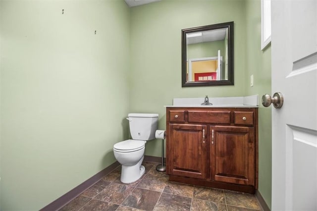 4188 Country Squire Ln, Oak Grove, MO 64075 - half bathroom featuring baseboards, vanity, toilet, and stone finish floors