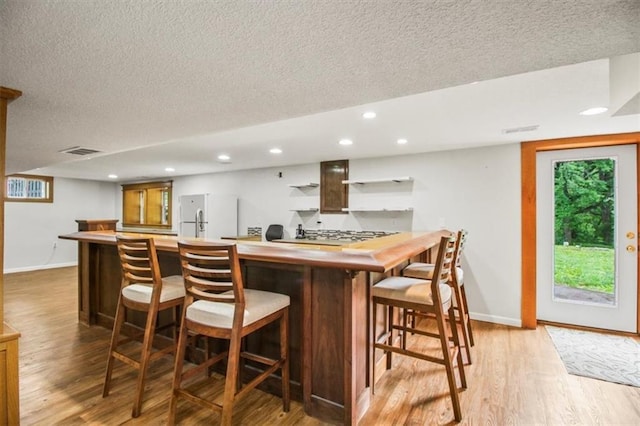 4188 Country Squire Ln, Oak Grove, MO 64075 - indoor bar featuring a textured ceiling, baseboards, light wood-style floors, recessed lighting, and freestanding refrigerator