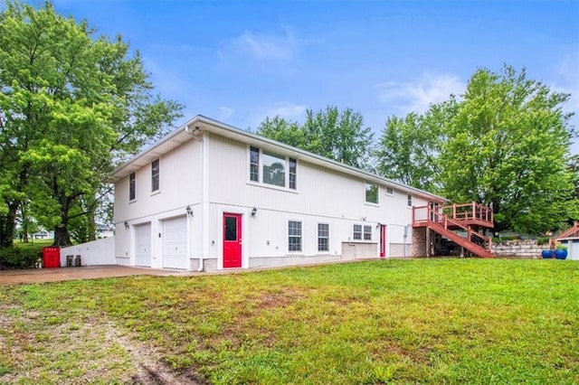 4188 Country Squire Ln, Oak Grove, MO 64075 - back of house with a garage, stairs, concrete driveway, a lawn, and a wooden deck