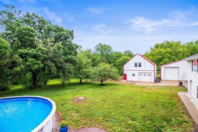 4188 Country Squire Ln, Oak Grove, MO 64075 - view of grassy yard with a detached garage, an outdoor structure, and an outdoor pool