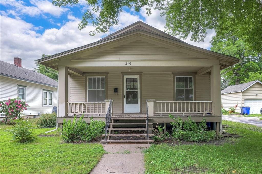 415 S Harrison St, Olathe, KS 66061 - shotgun-style home featuring covered porch and a front lawn