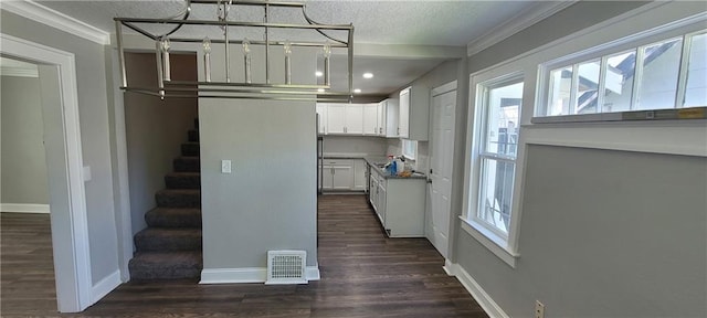 5118 Wabash Ave, Kansas City, MO 64130 - kitchen featuring ornamental molding, white cabinets, baseboards, recessed lighting, and dark wood-style flooring