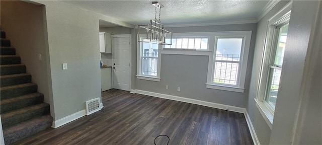 5118 Wabash Ave, Kansas City, MO 64130 - unfurnished dining area featuring stairway, healthy amount of natural light, dark wood-type flooring, a textured ceiling, and ornamental molding