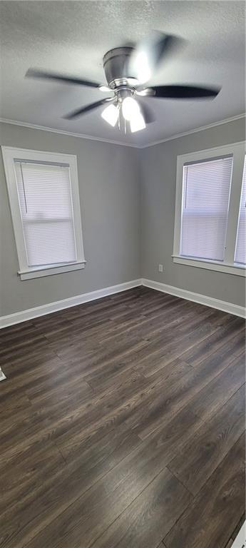 5118 Wabash Ave, Kansas City, MO 64130 - empty room with ornamental molding, a textured ceiling, dark wood-style floors, and baseboards