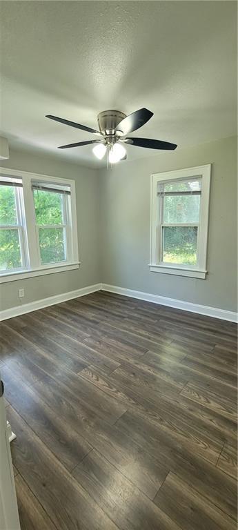 5118 Wabash Ave, Kansas City, MO 64130 - spare room featuring baseboards, dark wood-style flooring, and a ceiling fan