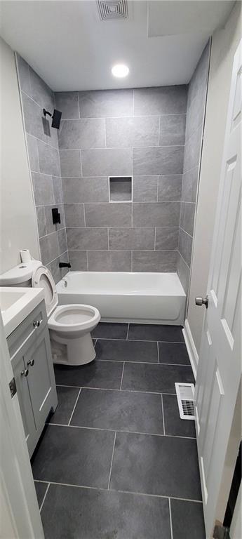 5118 Wabash Ave, Kansas City, MO 64130 - bathroom with vanity, toilet, tile patterned flooring, and bathtub / shower combination
