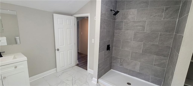 5118 Wabash Ave, Kansas City, MO 64130 - bathroom featuring vanity, marble finish flooring, tiled shower, baseboards, and lofted ceiling