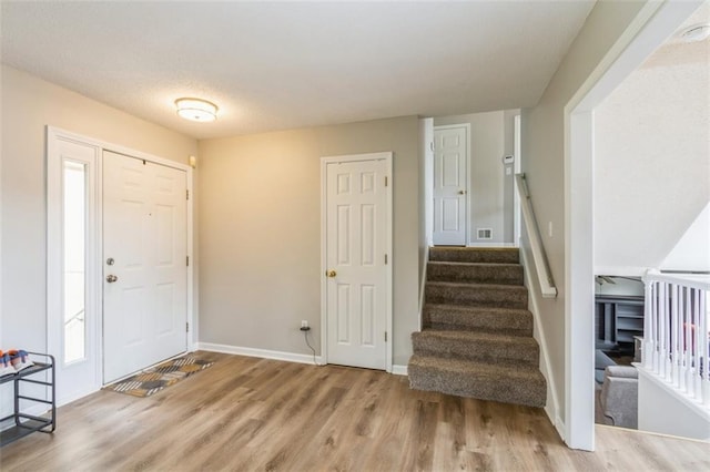 5309 NE Rainbow Cir, Lees Summit, MO 64064 - entryway with wood finished floors, stairs, and baseboards