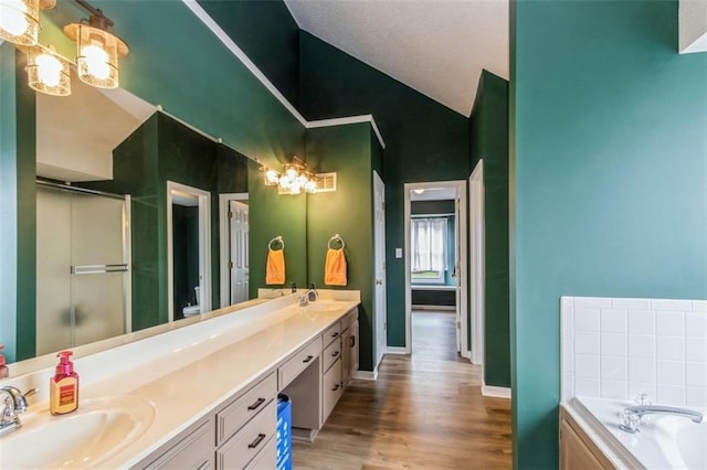 5309 NE Rainbow Cir, Lees Summit, MO 64064 - bathroom with double vanity, a bath, wood finished floors, a shower stall, and high vaulted ceiling