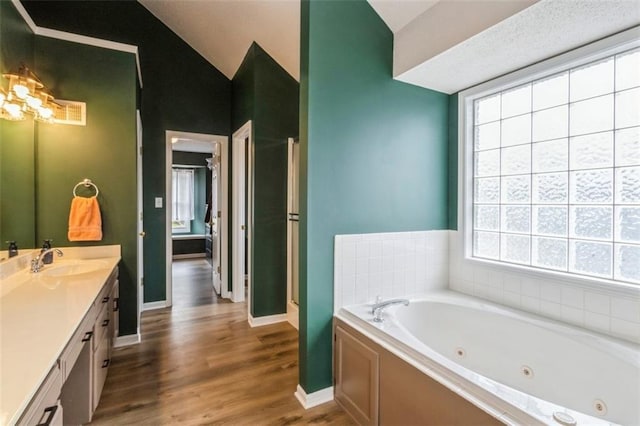 5309 NE Rainbow Cir, Lees Summit, MO 64064 - bathroom with vanity, a whirlpool tub, wood finished floors, lofted ceiling, and baseboards