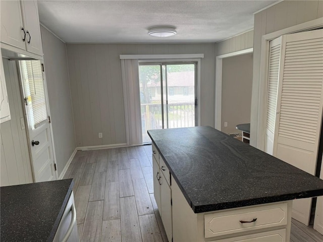 3006 S Santa Fe Rd, Independence, MO 64055 - kitchen featuring light wood-style flooring, baseboards, a textured ceiling, white cabinetry, and a center island