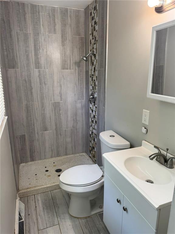 3006 S Santa Fe Rd, Independence, MO 64055 - bathroom with a shower stall, vanity, toilet, and wood finished floors