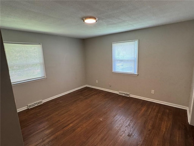 3006 S Santa Fe Rd, Independence, MO 64055 - unfurnished room with plenty of natural light, dark wood-style flooring, baseboards, and a textured ceiling
