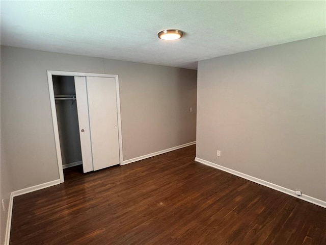 3006 S Santa Fe Rd, Independence, MO 64055 - unfurnished bedroom featuring dark wood-style floors, baseboards, and a closet