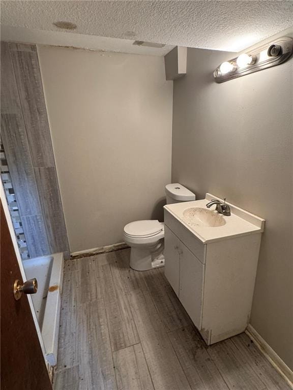 3006 S Santa Fe Rd, Independence, MO 64055 - full bathroom with wood finished floors, toilet, a textured ceiling, and vanity