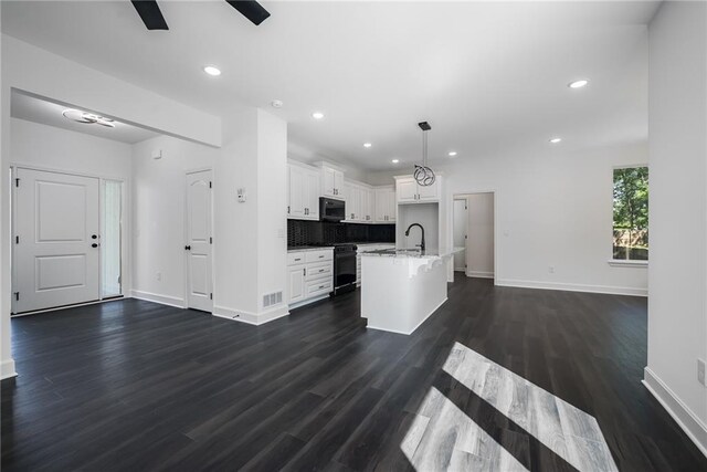 11147 Rowland Ave, Kansas City, KS 66109 - kitchen with black microwave, baseboards, gas stove, open floor plan, and recessed lighting