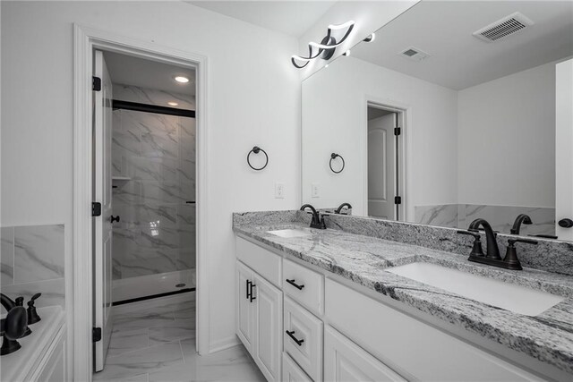 11147 Rowland Ave, Kansas City, KS 66109 - full bath with marble look tile flooring, a marble finish shower, and double vanity