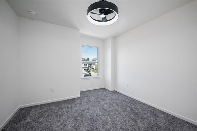 11147 Rowland Ave, Kansas City, KS 66109 - empty room featuring dark carpet, a smoke detector, and baseboards