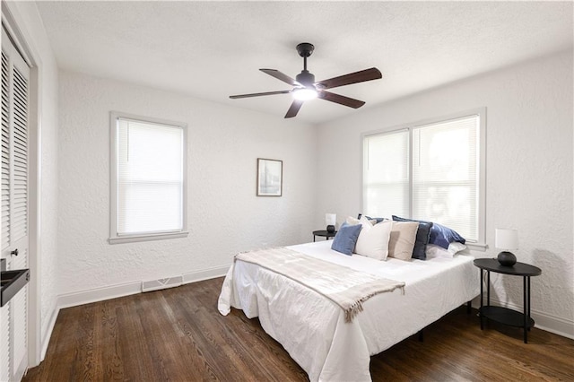 1617 N Pearl St, Independence, MO 64050 - bedroom with wood finished floors, a textured wall, multiple windows, and a ceiling fan