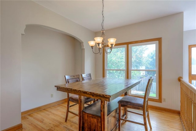 833 SW Harvest Dr, Grain Valley, MO 64029 - dining space featuring a chandelier, light wood-style flooring, arched walkways, and baseboards