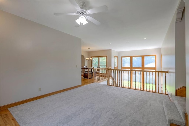 833 SW Harvest Dr, Grain Valley, MO 64029 - empty room with a ceiling fan, a chandelier, baseboards, and light wood-style flooring