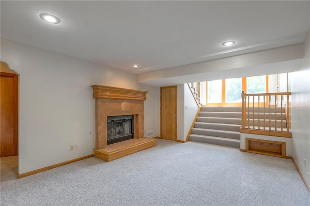 833 SW Harvest Dr, Grain Valley, MO 64029 - unfurnished living room featuring carpet, stairs, baseboards, a high end fireplace, and recessed lighting